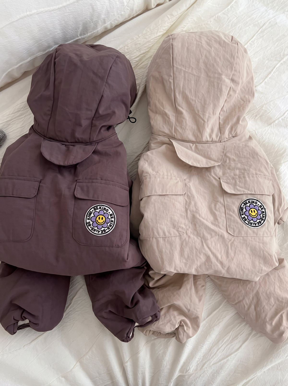Après hooded dog puffer suit, flat lay of the beige version next to a mauve one, with pockets and elastic cuffs - Malpetit