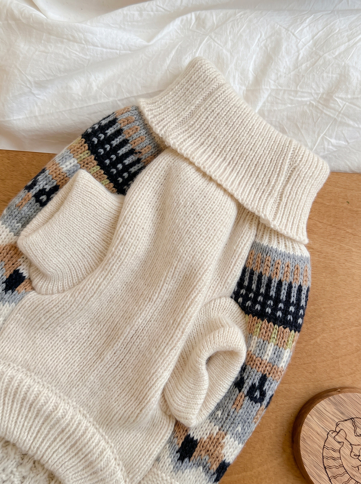 Chalet Blanc dog sweater on a wooden table, ribbed turtleneck and Nordic pattern on the sides - Malpetit