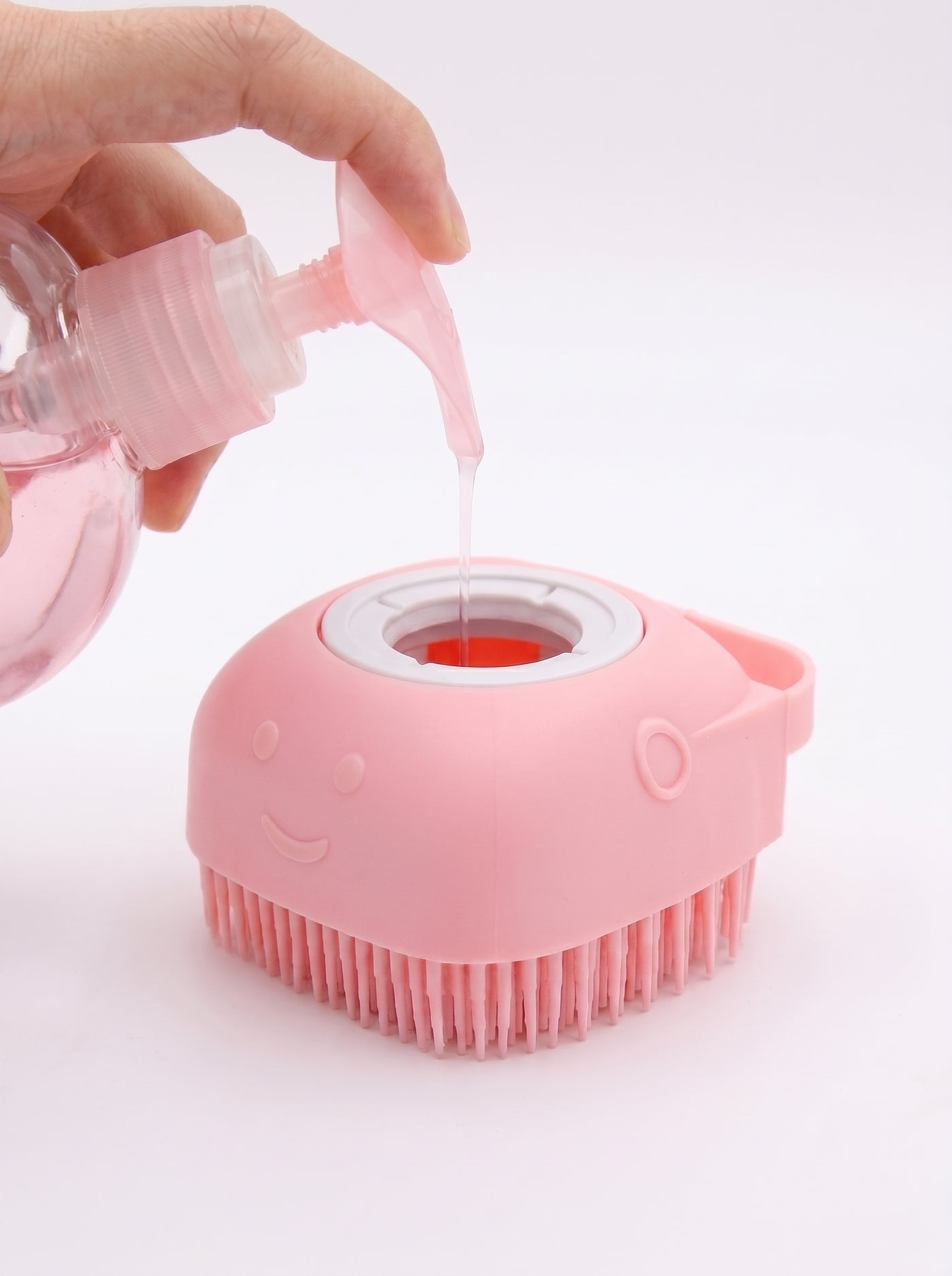 Pink silicone bath brush being filled with shampoo – Malpetit