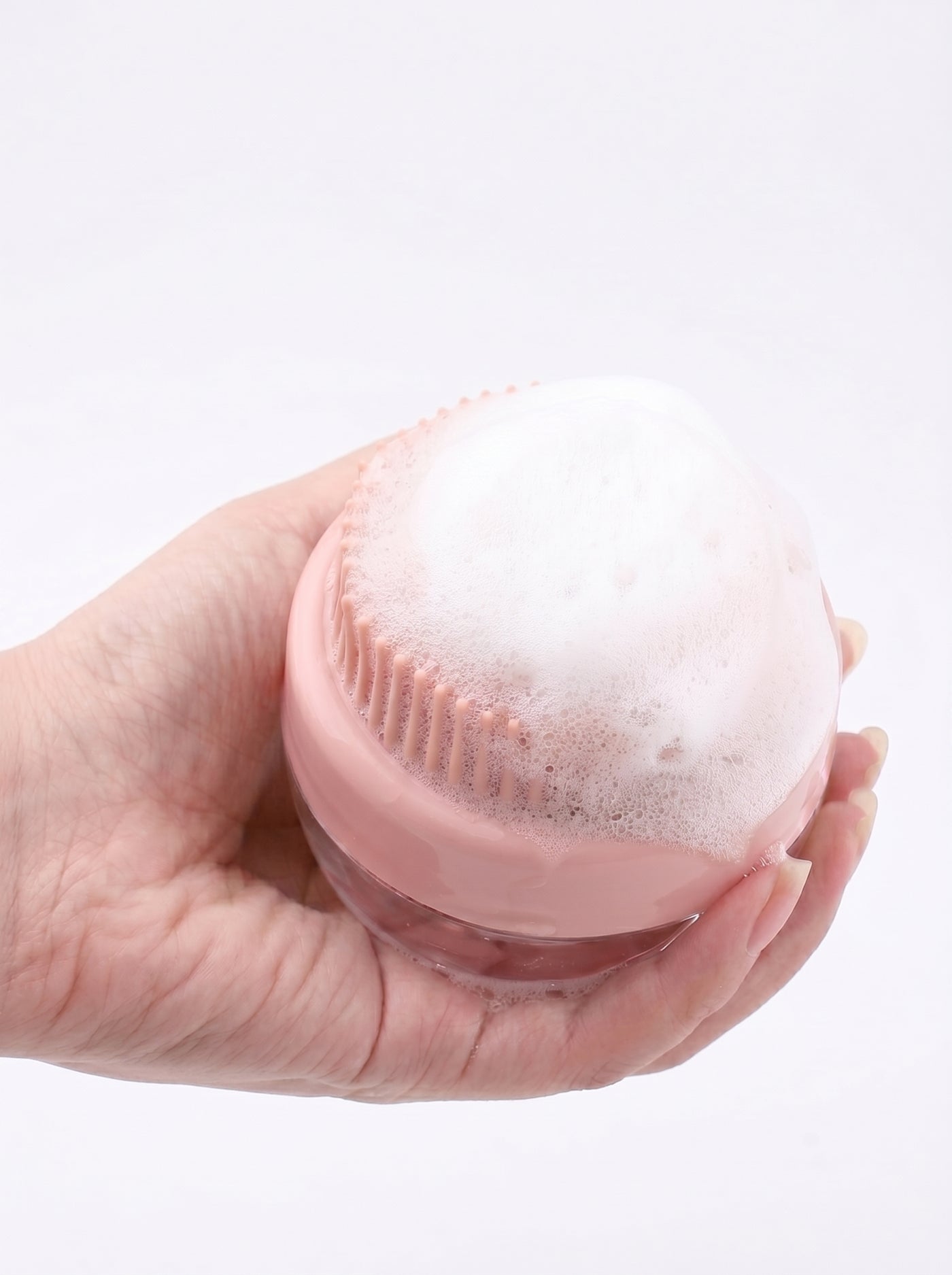 Silicone bath brush in hand with foam close-up – Malpetit