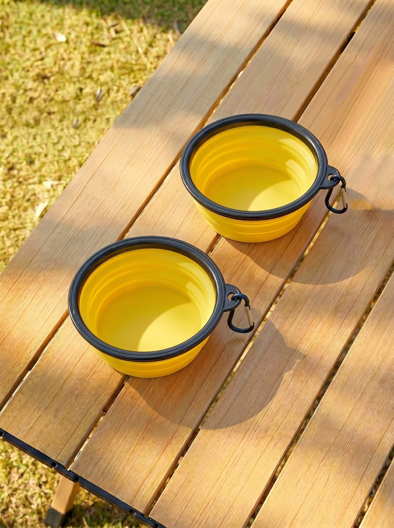 Two yellow foldable travel bowls on wooden table outdoors – Malpetit
