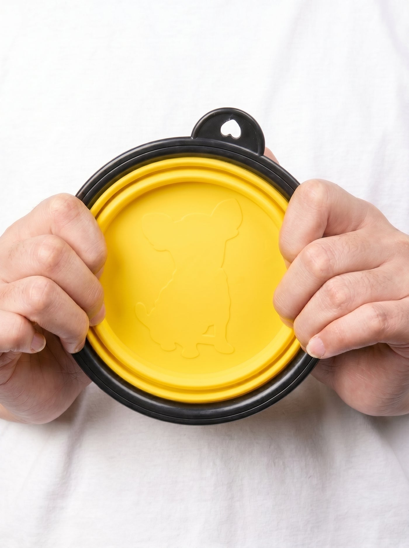Hands holding folded yellow foldable bowl with dog silhouette – Malpetit